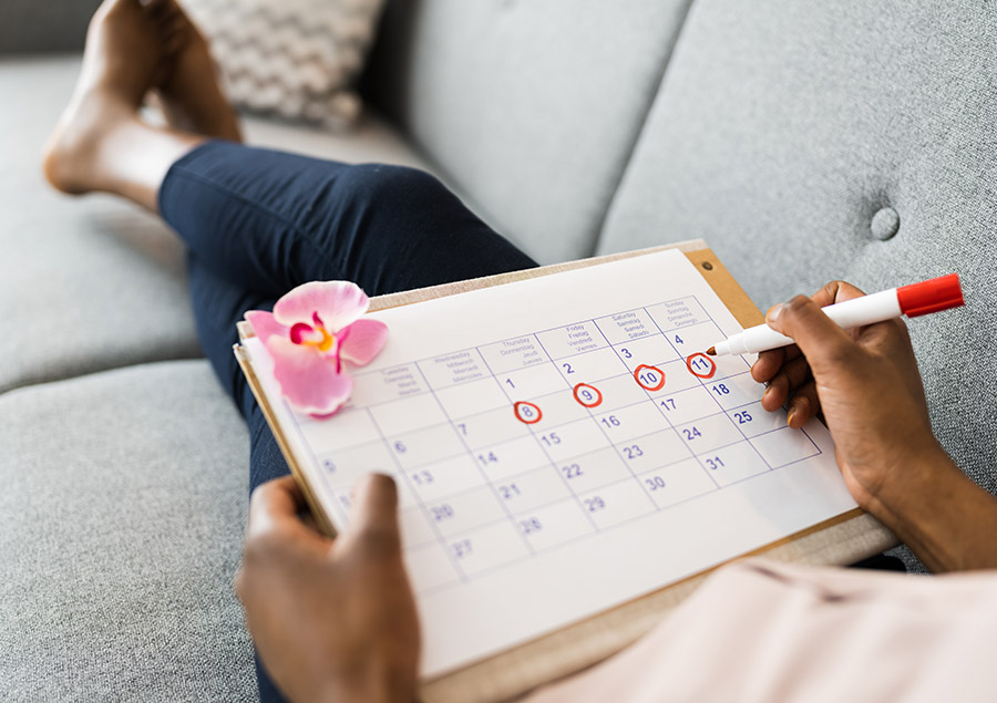 Frau mit Hämophilie markiert die Tage ihrer Menstruation in einem Kalender.